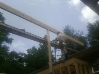 Carpenter setting a ridge beam over a new addition frame — Ice Dam Removal by Roofing Brothers in Vernon Rockville