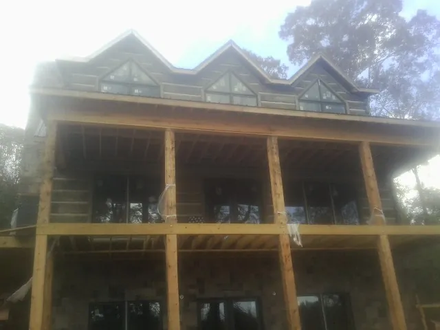 Dormers and porch framing on a large log home under construction — Roof Coating work by our crew in Vernon Rockville