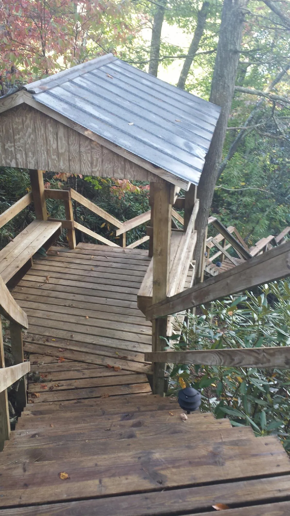 Metal roofed shelter over wooden steps on a wooded walkway — Skylight Repair & Installation work by our crew in Vernon Rockville