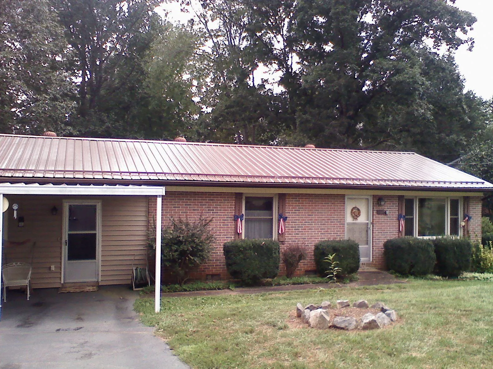 Bronze metal roof and carport on a brick ranch home — Roof Repair work by our crew in Vernon Rockville